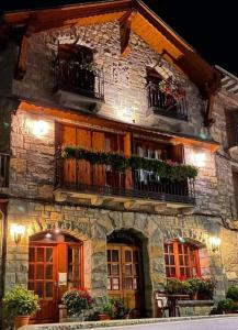 - un bâtiment en pierre avec des balcons et des plantes dans l'établissement Apartamentos Casa Español, à Broto