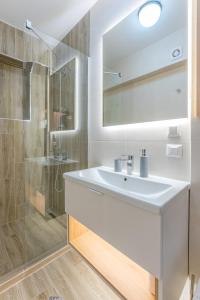 a bathroom with a white sink and a shower at Pretoria Luxor apartment Predeal in Predeal