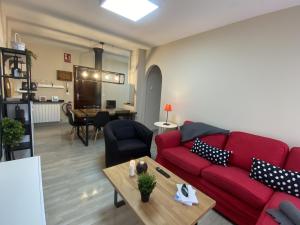 a living room with a red couch and a table at Apartamento en la playa con piscina - Azcona 6004 in Noja