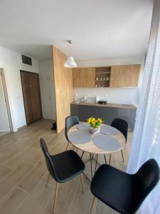 ein Wohnzimmer mit einem Tisch und Stühlen sowie eine Küche in der Unterkunft Goga Apartmani in Divčibare