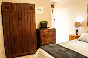 斯特爾拜的住宿－Elize Cottage，一间卧室配有木制橱柜和一张床