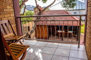 eine abgeschirmte Veranda mit einer Bank und einem Grill in der Unterkunft Elize Cottage in Stilbaai