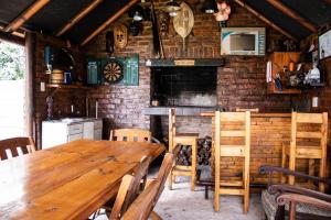 斯特爾拜的住宿－Elize Cottage，一间设有木桌和砖墙的用餐室