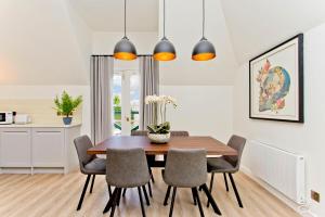 a kitchen and dining room with a wooden table and chairs at Newly Reno'd 2 Bed with Free Parking in Edinburgh