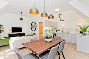 a kitchen and living room with a wooden table and chairs at Newly Reno'd 2 Bed with Free Parking in Edinburgh +27 photos