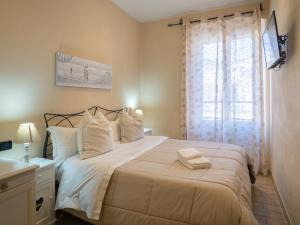 una camera da letto con un letto con lenzuola bianche e una finestra di Affittacamere Lunamar a La Spezia