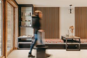 a person walking through a room with a bed at Vail Lodge by Alpine Residences in Val-d'Isère