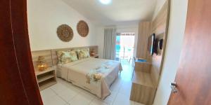1 dormitorio con 1 cama y TV en una habitación en Pousada Mar e Brisa, en Natal
