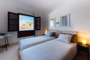 dwa łóżka w pokoju hotelowym z oknem w obiekcie El Buen Retiro w mieście Playa Blanca +14 zdjęć