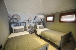 1 dormitorio con 2 camas y un mural de animales en Alp Suites Mandalin, en Akyaka
