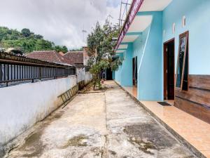 a walkway outside a house with blue walls at OYO Life 90879 Ara Predator Funpark in Batu