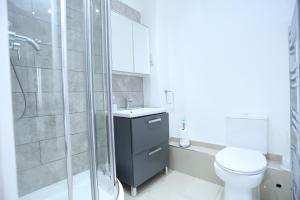 a bathroom with a toilet and a glass shower at Classic Studio Lytham Up London in London