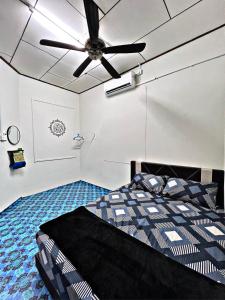 1 dormitorio con 1 cama y ventilador de techo en FA HOMESTAY KUALA TERENGGANU, en Kuala Terengganu