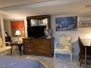a bedroom with a bed and a tv and a dresser at Highland Park Pittsburgh in Pittsburgh