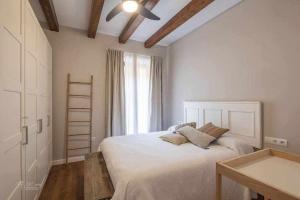 ein Schlafzimmer mit einem weißen Bett und einem Fenster in der Unterkunft Parking Free - Cathedral Area Apartment in Sevilla