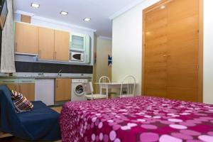 1 dormitorio con cama morada y cocina en Suitur Apartment Hita I Centro Madrid, en Madrid
