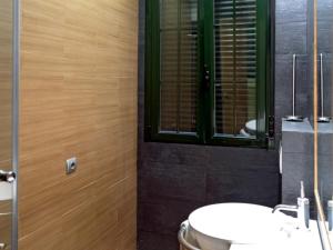 a bathroom with a toilet and a sink and a window at Suitur Apartment Hita III Centro Madrid in Madrid