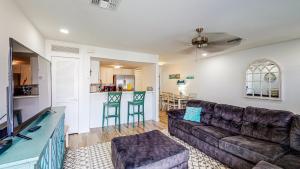 ein Wohnzimmer mit einem Sofa und einer Küche in der Unterkunft EC234 Newly Remodeled, One Bedroom, Second Floor Condo, Shared Pool, Grills and Boardwalk in Port Aransas