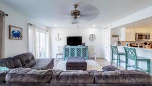 a living room with a couch and a kitchen at EC234 Newly Remodeled, One Bedroom, Second Floor Condo, Shared Pool, Grills and Boardwalk in Port Aransas