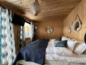 a bedroom with a bed and a wooden ceiling at The Novac's Cottage in Råneå