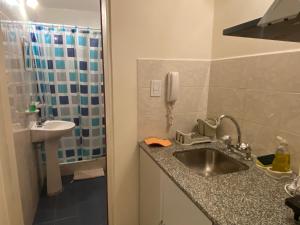 a bathroom with a sink and a shower with a phone at Departamento Belgrano 11 in Salta