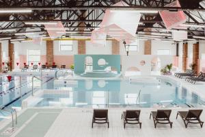 una gran piscina con sillas en un edificio en Cukrownia Żnin, en Żnin