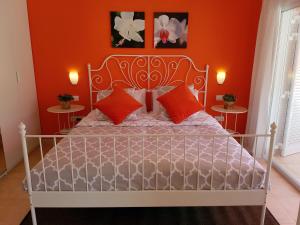 a bedroom with a white bed with orange walls at Paraiso Puerto de Mogan in Puerto de Mogán