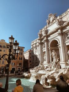 a group of people sitting around the trevi fountain at Residenza Tritone Luxury Guest House Trevi Fountain in Rome +75 photos