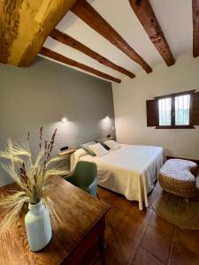 a bedroom with a bed and a wooden table at Hotel Caseta Nova in Castalla