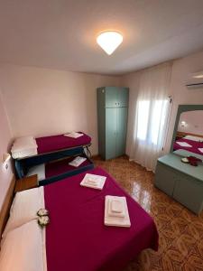 a small room with two beds and a mirror at Hotel Villa Cristina in Rimini
