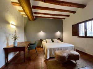 a bedroom with a bed and a table and a desk at Hotel Caseta Nova in Castalla