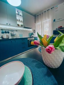 a vase of flowers sitting on a table in a kitchen at Apartment One Brasov in Braşov