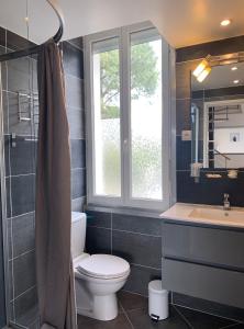 La salle de bains est pourvue de toilettes, d'un lavabo et d'une fenêtre. dans l'établissement Appartement Du Lac, à Hossegor