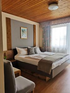 a bedroom with a large bed and a window at Pension Arkadenhof in Loipersdorf bei Fürstenfeld