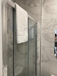 a bathroom with a shower with a towel hanging on the wall at Lady Hamilton Inn in Portsmouth