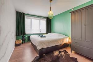 sypialnia z łóżkiem i zieloną ścianą w obiekcie Private trendy appartement toplocatie Middelkerke w mieście Middelkerke