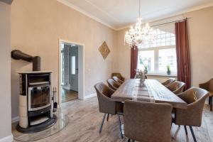 a dining room with a table and a wood stove at Villa an der Bode in Thale