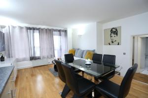 a living room with a dining room table and chairs at Gorgeous 2 bedroom 2 bathroom Woolwich in Woolwich