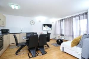 a kitchen and living room with a table and chairs at Gorgeous 2 bedroom 2 bathroom Woolwich in Woolwich