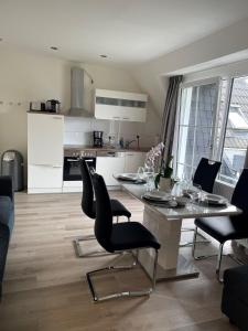 a kitchen and dining room with a table and chairs at Seaside-Amrum-13 in Norddorf