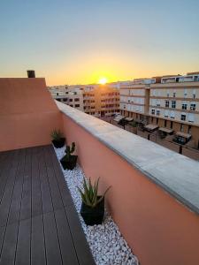 a balcony of a building with a sunset in the background at MEDANO4YOU Kevin's Penthouse in El Médano