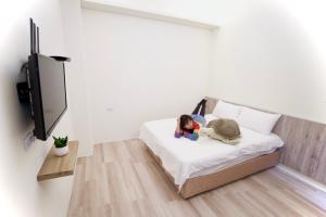 a little girl laying on a bed with a stuffed animal at It's Mine Hostel in Taitung City