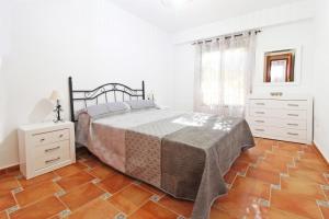 a bedroom with a bed and a wooden floor at Global Properties, El Coquetón - Bonito y tranquilo apartamento en Canet playa in Canet de Berenguer