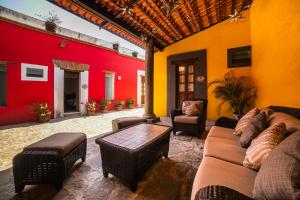 una sala de estar con sofás y una pared roja y amarilla. en Collection O Al otro lado del rio, Puebla en Puebla