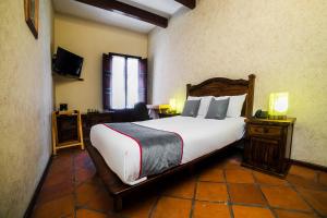 a bedroom with a large bed and a television at Collection O Al otro lado del rio, Puebla in Puebla