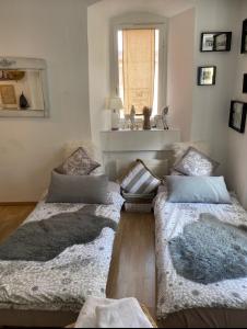 2 Betten im Wohnzimmer mit Fenster in der Unterkunft Pünctchen in Chur
