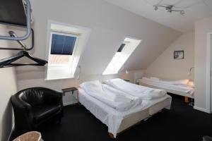 ein Zimmer mit 2 Betten und einem Stuhl darin in der Unterkunft Skråvej Bed & Breakfast in Skagen
