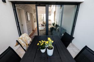 uma mesa de madeira com flores numa varanda em Adele Apartments em Pécs