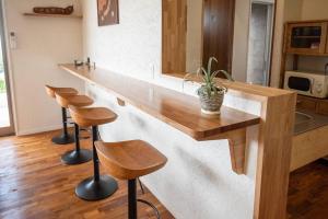 a kitchen with a counter with stools and a counter top at villa modama in Nanjo