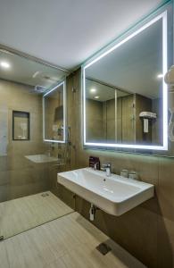 łazienka z umywalką i dużym lustrem w obiekcie HOTEL ANS PRIDE Pudukkottai w mieście Pudukkottai